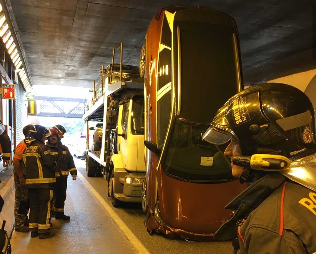 Un camión portacoches clava un vehículo en el techo de un túnel