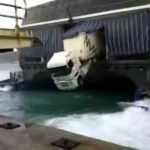 Camión colgando por la popa de un barco